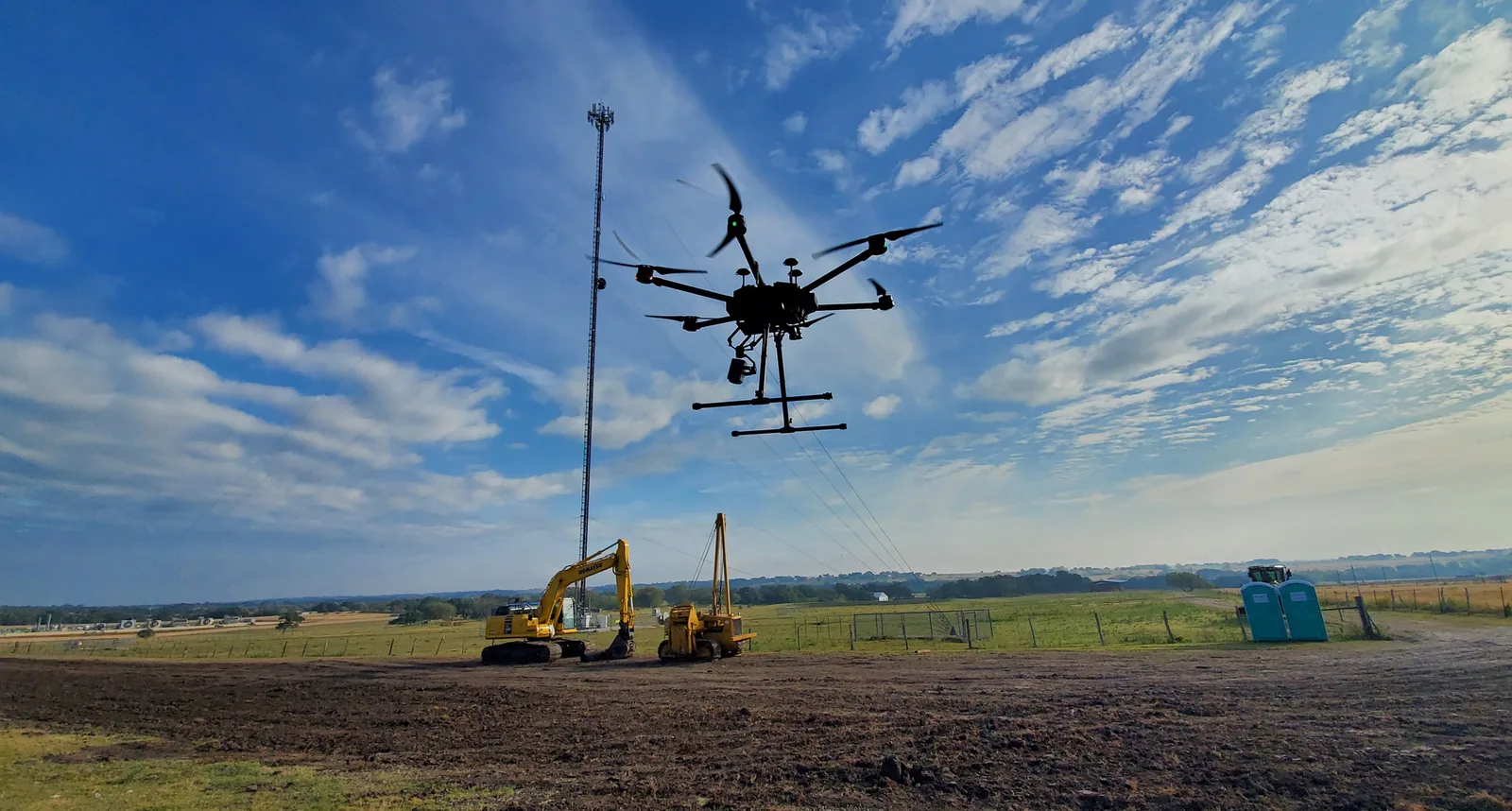 Survey drone operating above an active project site